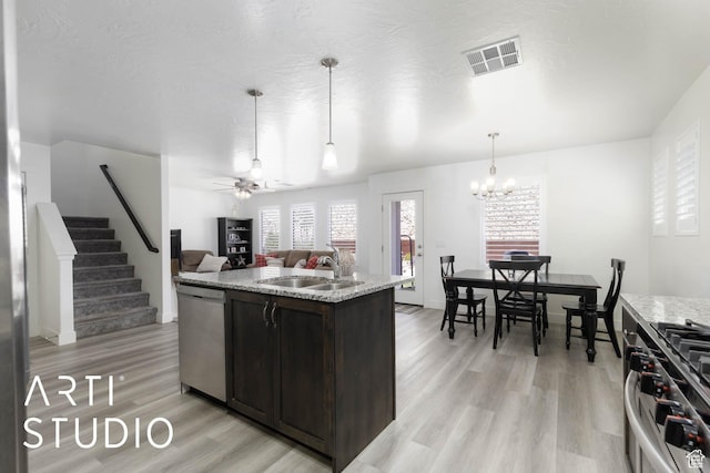6297 S Zelda Dr, St George, UT 84790 - kitchen with stainless steel appliances, dark brown cabinetry, light wood-style flooring, open floor plan, and light stone counters