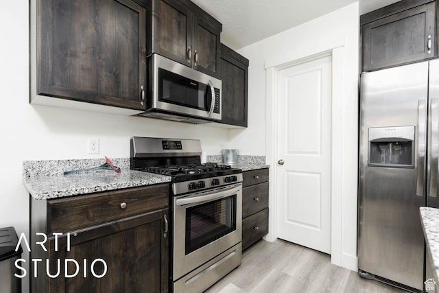 6297 S Zelda Dr, St George, UT 84790 - kitchen with stainless steel appliances, dark brown cabinets, light wood-type flooring, and light stone countertops
