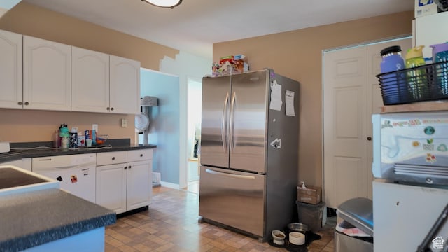 2617 S Ridgeland W, West Valley City, UT 84119 - kitchen featuring freestanding refrigerator, white dishwasher, dark countertops, and white cabinetry