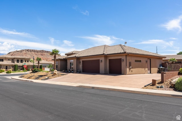 1883 S Purple Sage Dr, Washington, UT 84780 - view of front facade featuring stucco siding, a tile roof, an attached garage, and driveway