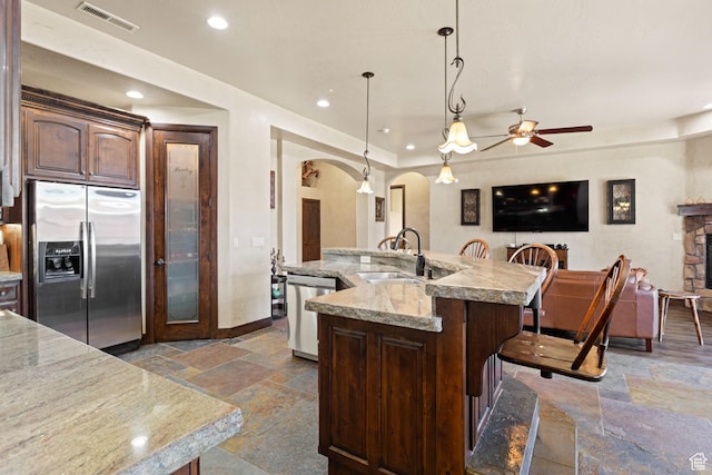 1883 S Purple Sage Dr, Washington, UT 84780 - kitchen featuring appliances with stainless steel finishes, stone tile flooring, arched walkways, ceiling fan, and recessed lighting