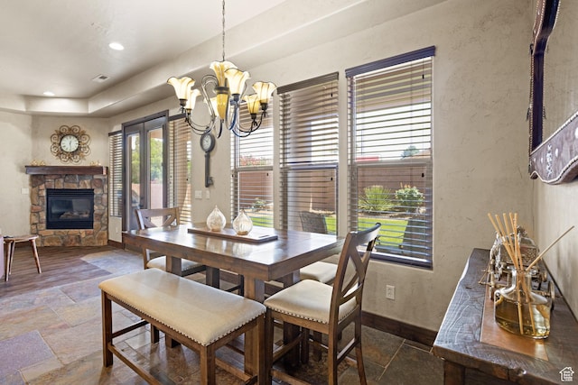 1883 S Purple Sage Dr, Washington, UT 84780 - dining area featuring stone tile flooring, a stone fireplace, a chandelier, a textured wall, and recessed lighting