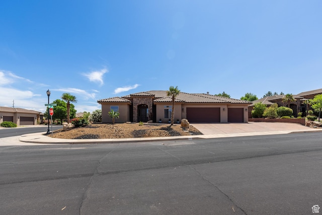 1883 S Purple Sage Dr, Washington, UT 84780 - mediterranean / spanish house with an attached garage, a tiled roof, concrete driveway, and stucco siding