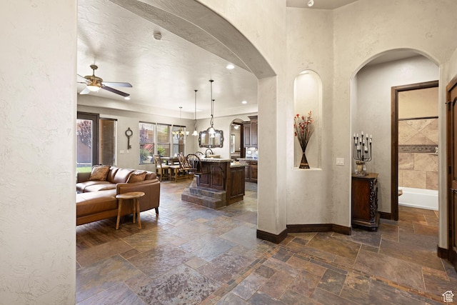 1883 S Purple Sage Dr, Washington, UT 84780 - living area featuring arched walkways, stone tile flooring, a ceiling fan, and a textured wall