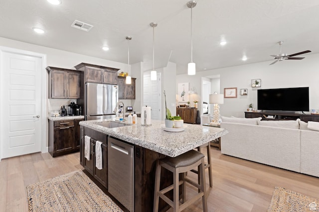 2723 S Varano Way, St George, UT 84770 - kitchen featuring stainless steel appliances, light wood-style floors, dark brown cabinets, open floor plan, and a ceiling fan