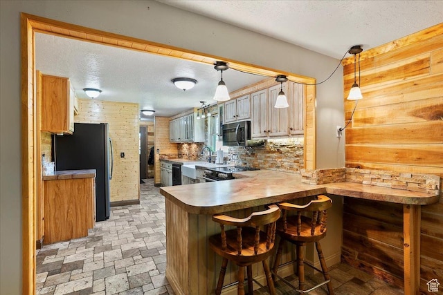 409 N 9000 E, Huntsville, UT 84317 - kitchen featuring black appliances, a peninsula, a textured ceiling, a breakfast bar area, and hanging light fixtures