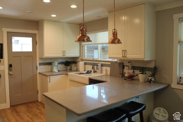 1268 E Edenbrook Dr, Sandy, UT 84094 - kitchen featuring plenty of natural light, recessed lighting, a peninsula, tasteful backsplash, and a kitchen bar