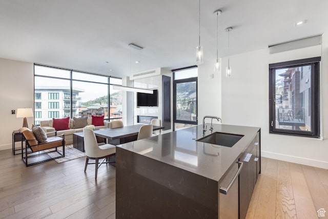 2431 W High Mountain Rd Unit 504, Park City, UT 84098 - kitchen featuring an island with sink, modern cabinets, light wood finished floors, plenty of natural light, and a wall of windows
