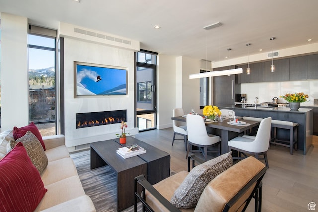 2431 W High Mountain Rd Unit 504, Park City, UT 84098 - living area featuring wood finished floors, a lit fireplace, recessed lighting, and a wall of windows