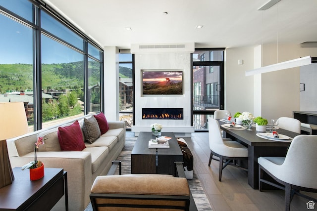 2431 W High Mountain Rd Unit 504, Park City, UT 84098 - living room with expansive windows, wood-type flooring, and a warm lit fireplace