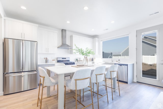 2719 N 2775 W Unit 120, Plain City, UT 84404 - kitchen featuring stainless steel appliances, wall chimney exhaust hood, a kitchen island, a breakfast bar area, and light countertops