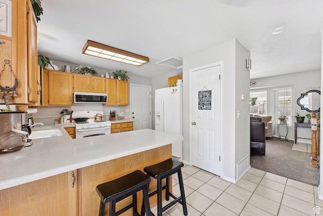 3573 S Deann Dr W, West Valley City, UT 84128 - kitchen featuring white appliances, light countertops, a peninsula, light tile patterned flooring, and light carpet