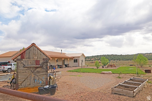 7395 N Johnson Canyon Rd, Kanab, UT 84741 - rear view of property featuring a garden and a metal roof