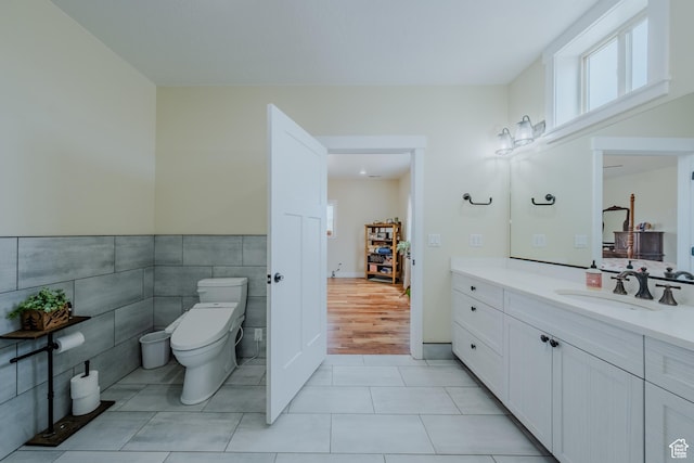 7395 N Johnson Canyon Rd, Kanab, UT 84741 - bathroom featuring vanity, healthy amount of natural light, tile patterned floors, tile walls, and a wainscoted wall