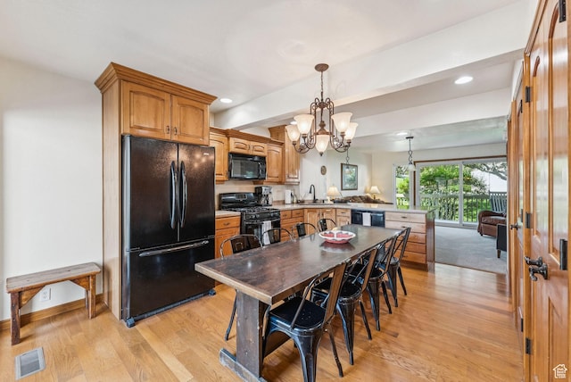 171 Dunlop Ct, Park City, UT 84060 - kitchen with black appliances, a peninsula, light wood finished floors, a chandelier, and light countertops