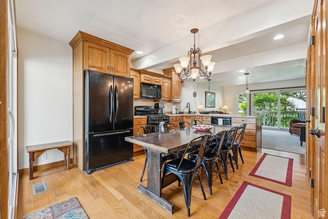 171 Dunlop Ct, Park City, UT 84060 - kitchen featuring black appliances, a peninsula, light wood finished floors, a chandelier, and recessed lighting