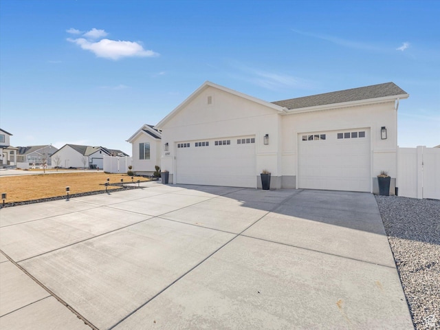 2297 N 250 W, Tooele, UT 84074 - view of front of home with a garage, driveway, stucco siding, and a residential view