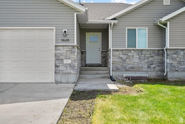 18605 N 6000 W, Riverside, UT 84334 - property entrance featuring stone siding, an attached garage, a yard, roof with shingles, and concrete driveway