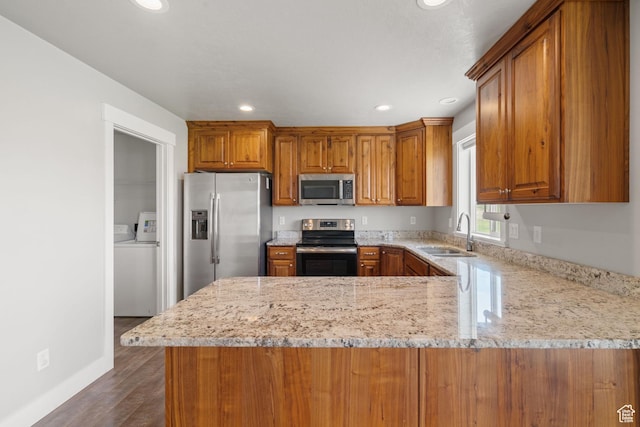 18605 N 6000 W, Riverside, UT 84334 - kitchen with stainless steel appliances, brown cabinetry, a peninsula, dark wood finished floors, and recessed lighting