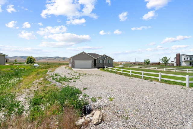 18605 N 6000 W, Riverside, UT 84334 - view of front of property with gravel driveway, a garage, a view of countryside, and a mountain view