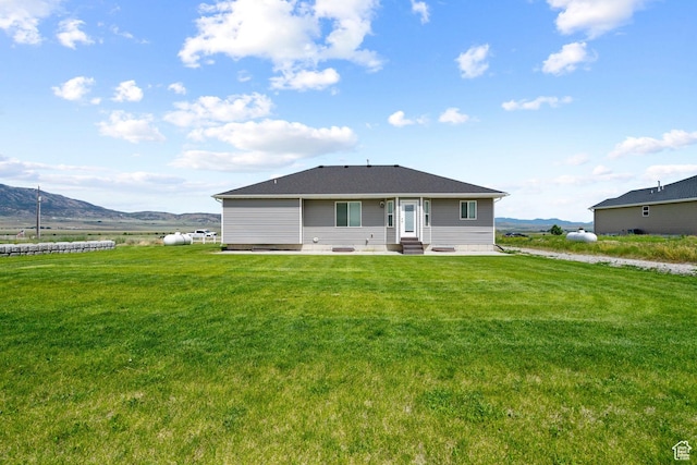 18605 N 6000 W, Riverside, UT 84334 - rear view of property with entry steps, a patio area, a mountain view, and a yard