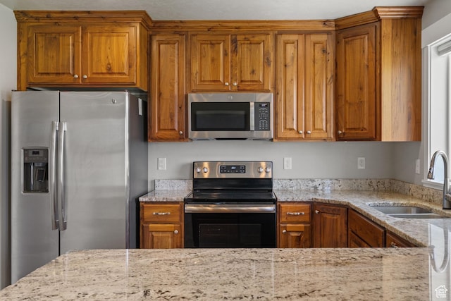 18605 N 6000 W, Riverside, UT 84334 - kitchen featuring stainless steel appliances, brown cabinets, and light stone counters