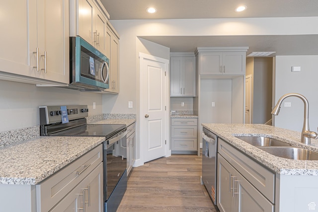 2202 S 1120 W Unit 64, Nibley, UT 84321 - kitchen with stainless steel appliances, light wood-style floors, recessed lighting, light stone counters, and gray cabinetry
