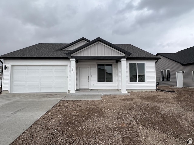 968 W 880 N Unit 59, Tremonton, UT 84337 - view of front of home featuring driveway, a garage, a shingled roof, and covered porch