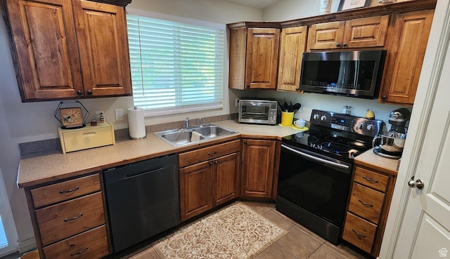 1751 E Canary Way, Eagle Mountain, UT 84005 - kitchen with black range with electric stovetop, dishwashing machine, light countertops, brown cabinets, and light tile patterned flooring