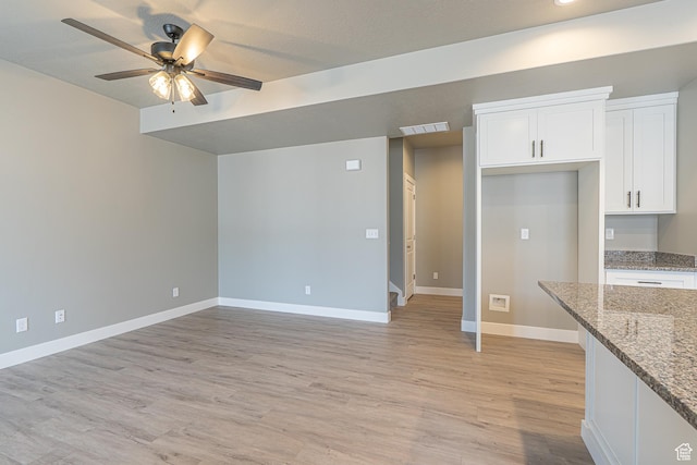 2206 S 1120 W Unit 65, Nibley, UT 84321 - kitchen with ceiling fan, white cabinetry, light stone countertops, and light wood-type flooring