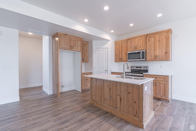 2214 S 1120 W Unit 67, Nibley, UT 84321 - kitchen with stainless steel appliances, light countertops, wood finished floors, recessed lighting, and a kitchen island with sink