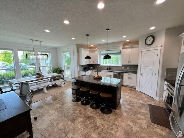 4053 W 3770 S, Wellsville, UT 84339 - kitchen with appliances with stainless steel finishes, a kitchen island, backsplash, recessed lighting, and white cabinets