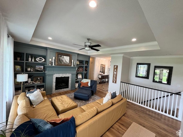 4053 W 3770 S, Wellsville, UT 84339 - living room featuring a raised ceiling, wood finished floors, a fireplace, ceiling fan, and crown molding