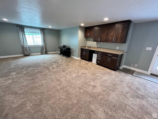 4053 W 3770 S, Wellsville, UT 84339 - kitchen featuring a textured ceiling, dark brown cabinetry, light countertops, light colored carpet, and recessed lighting