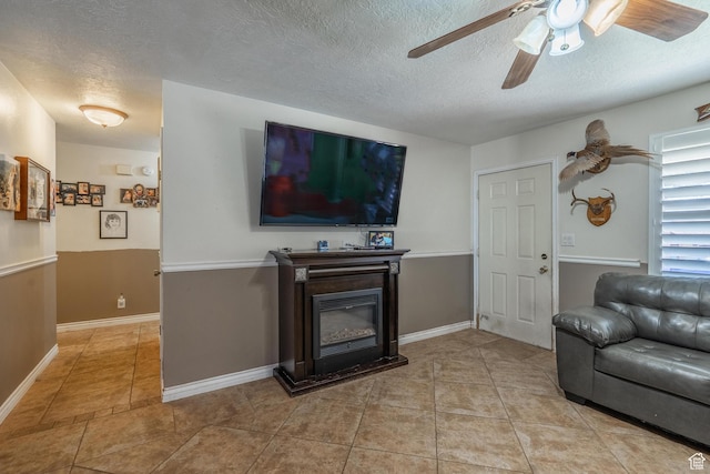 737 Carma Way, Washington, UT 84780 - living room with a ceiling fan, a textured ceiling, light tile patterned floors, and a glass covered fireplace