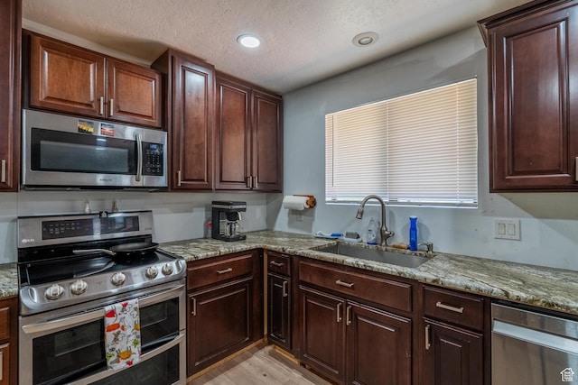 737 Carma Way, Washington, UT 84780 - kitchen featuring stainless steel appliances, light stone counters, light wood-style flooring, a textured ceiling, and recessed lighting
