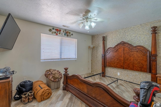 737 Carma Way, Washington, UT 84780 - bedroom with light wood finished floors, a textured ceiling, ceiling fan, and wallpapered walls
