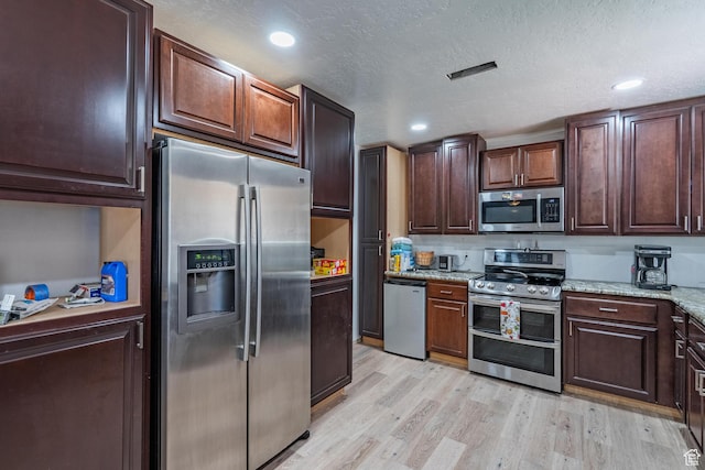 737 Carma Way, Washington, UT 84780 - kitchen featuring appliances with stainless steel finishes, light wood finished floors, light stone counters, dark brown cabinetry, and recessed lighting
