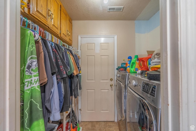 737 Carma Way, Washington, UT 84780 - laundry room featuring washing machine and clothes dryer, light tile patterned floors, a textured ceiling, and cabinet space