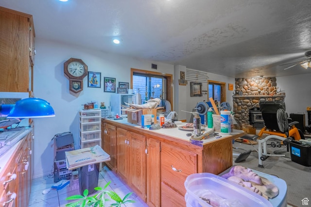 737 Carma Way, Washington, UT 84780 - kitchen featuring open floor plan, a wood stove, brown cabinetry, ceiling fan, and light countertops