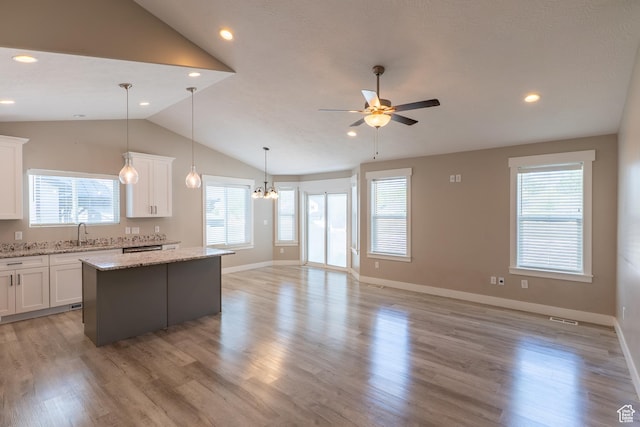 3867 N Chapman Dr, Eagle Mountain, UT 84005 - kitchen with vaulted ceiling, a center island, open floor plan, white cabinetry, and ceiling fan