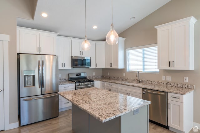 3867 N Chapman Dr, Eagle Mountain, UT 84005 - kitchen featuring appliances with stainless steel finishes, lofted ceiling, white cabinets, a kitchen island, and light stone countertops