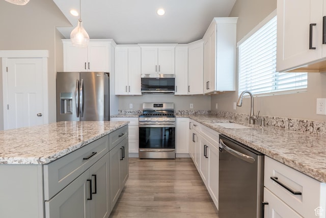 3867 N Chapman Dr, Eagle Mountain, UT 84005 - kitchen with stainless steel appliances, recessed lighting, light wood finished floors, white cabinets, and light stone counters