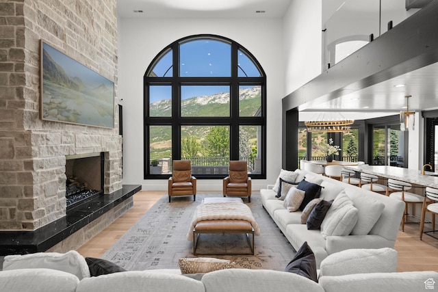 1643 E Box Elder Dr, Alpine, UT 84004 - living room featuring a stone fireplace, wood finished floors, and a towering ceiling