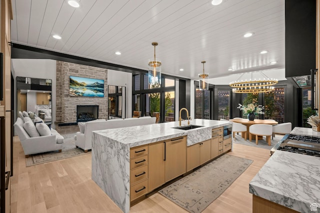 1643 E Box Elder Dr, Alpine, UT 84004 - kitchen with wood ceiling, light brown cabinets, a stone fireplace, light stone counters, and a large island