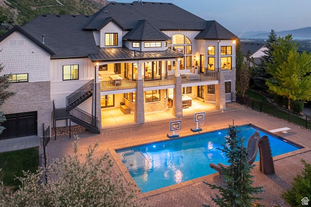 1643 E Box Elder Dr, Alpine, UT 84004 - back of property with a standing seam roof, stairway, a patio area, a metal roof, and an outdoor pool