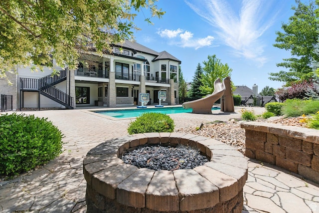 1643 E Box Elder Dr, Alpine, UT 84004 - rear view of house featuring an outdoor fire pit, a balcony, an outdoor pool, a patio, and stairs