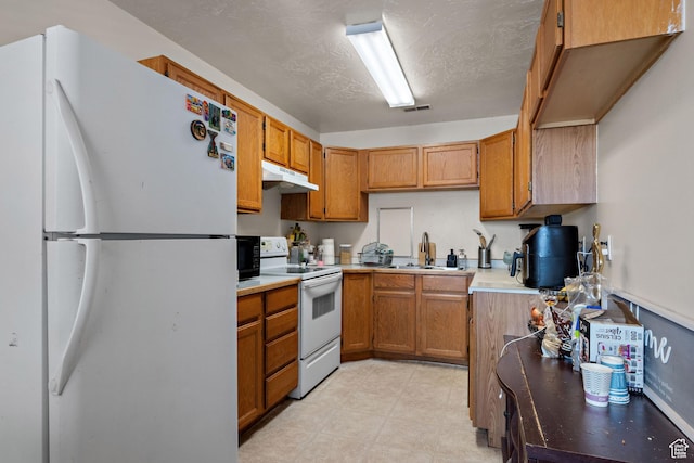 835 E 500 N, Spanish Fork, UT 84660 - kitchen featuring white appliances, under cabinet range hood, brown cabinetry, light countertops, and a textured ceiling