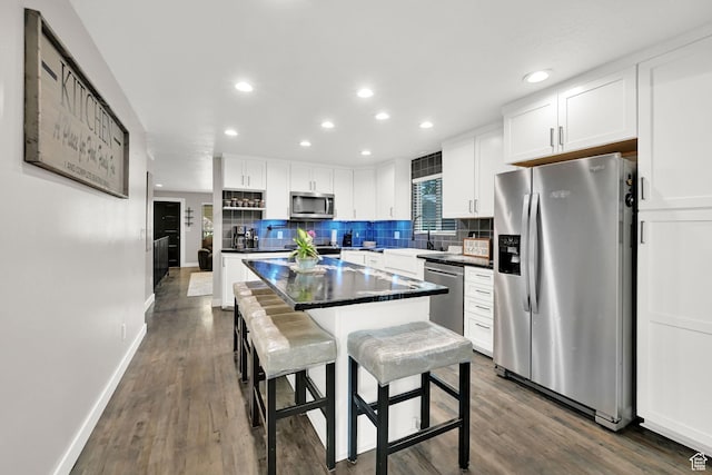 122 W 5300 S, Washington Terrace, UT 84405 - kitchen featuring stainless steel appliances, white cabinetry, dark countertops, backsplash, and a kitchen island