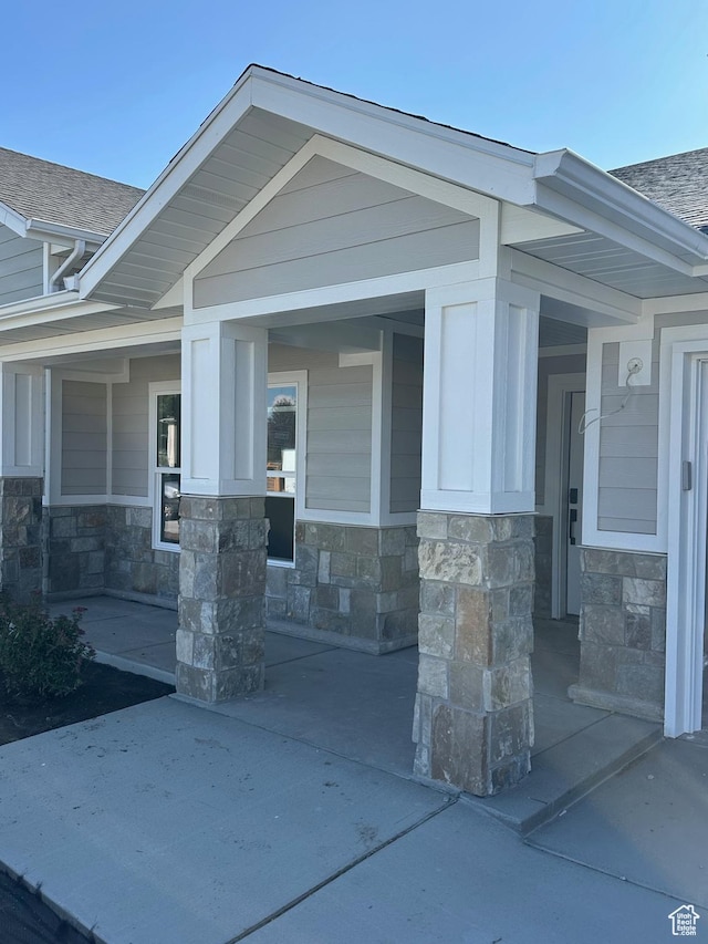 2613 S 2430 W Unit 111, Syracuse, UT 84075 - view of exterior entry featuring stone siding and a shingled roof